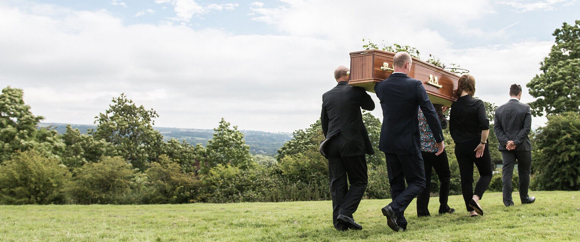 5 People carrying a coffin in a field