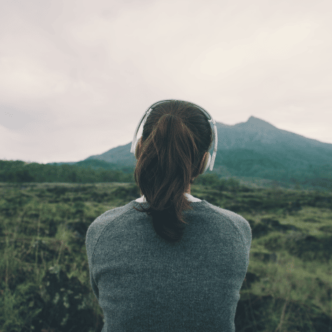 Woman in headphones looking at hills