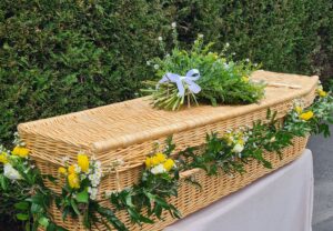 Wicker coffin with garland and spray