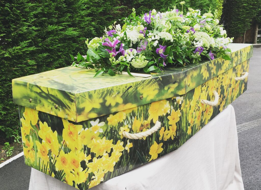 Daffodil cardboard picture coffin printed purple yellow flower spray