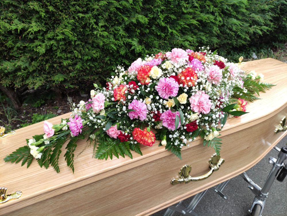 Pink flowers on wooden coffin