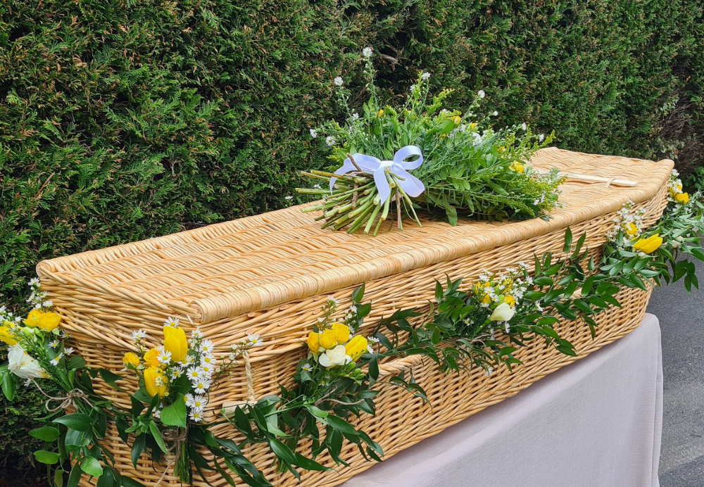 Wicker coffin with flower garland