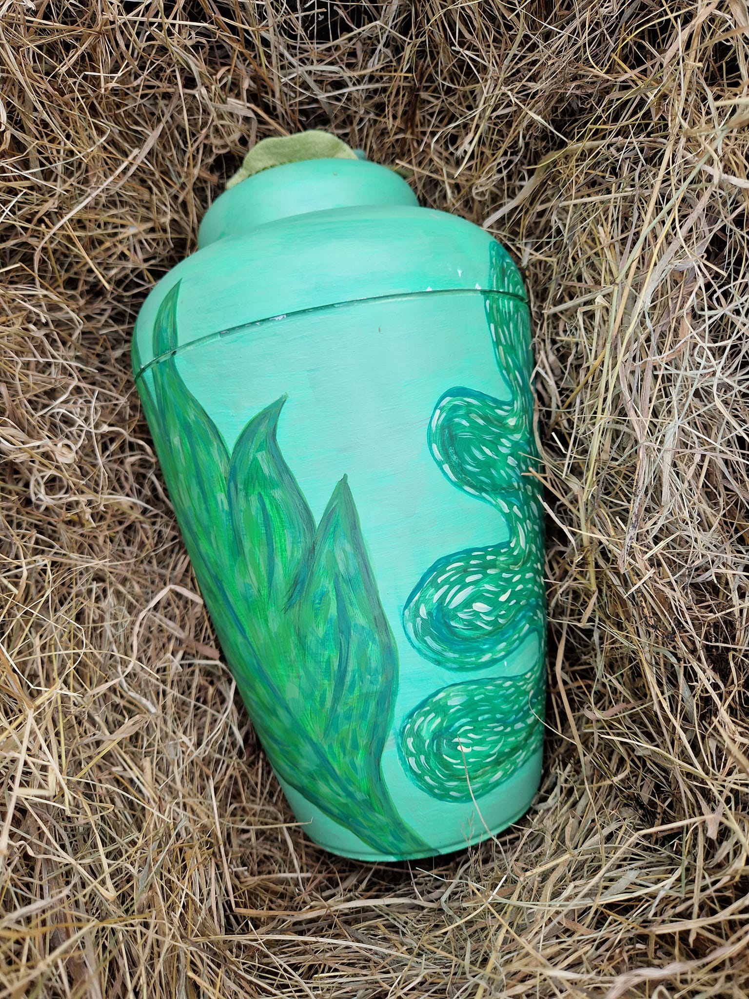 Green, hand decorated urn for ashes after a direct cremation funeral