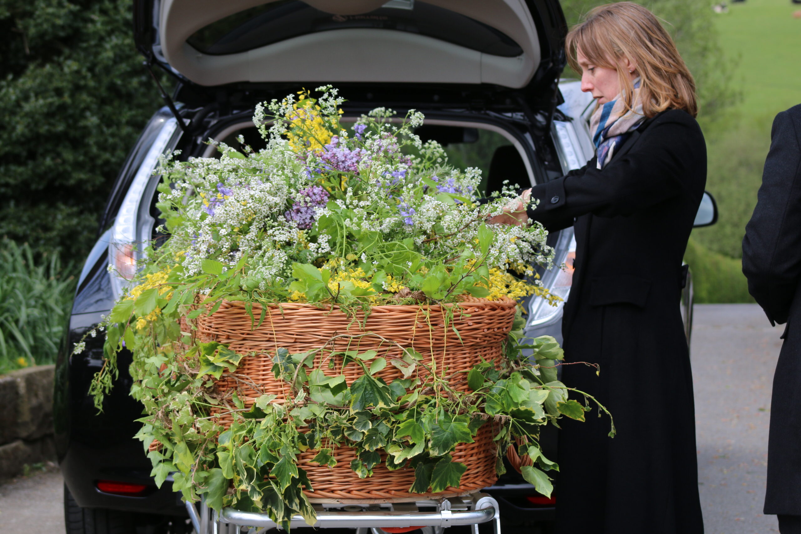 Coffin with flowers entering hearse for funeral