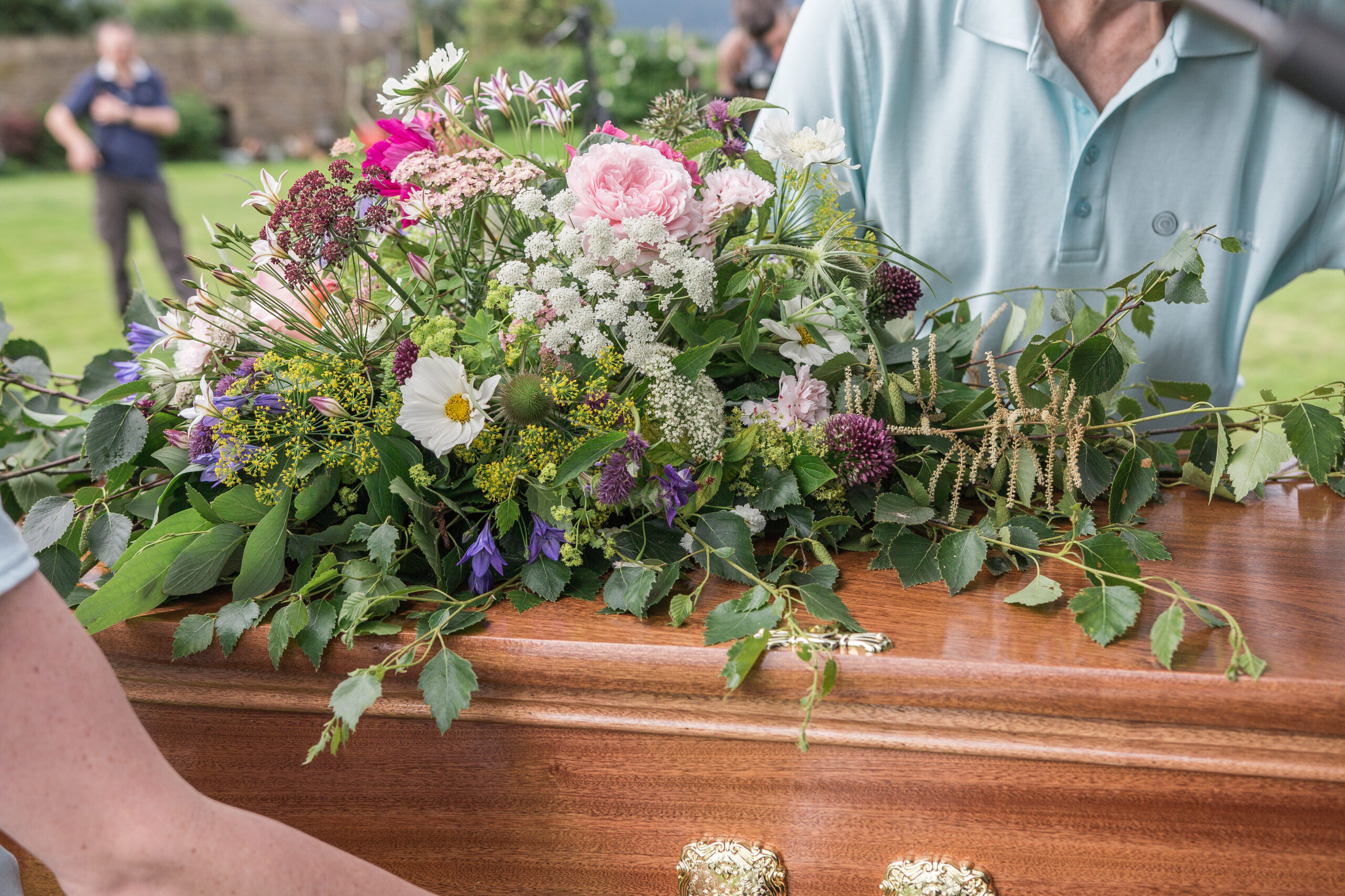 Placing a woodem coffin in to a hearse - the sort of coffin someone might choose in their funeral wishes